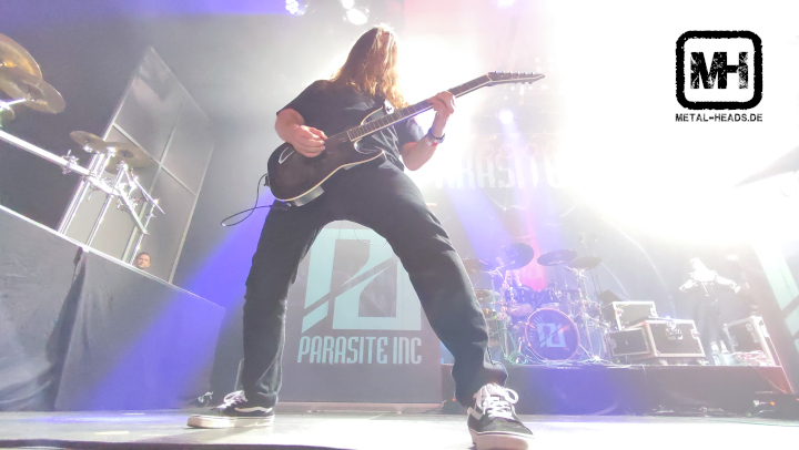 Parasite Inc. live auf dem Cypefest 2022: Ein Gitarrist steht breitbeinig, zwischen den Beinen sieht man den kompletten Schriftzug der Band.