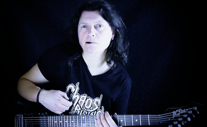Stéphanie Nolf mit E-Gitarre in der Hand und Plektrum zwischen den Lippen
