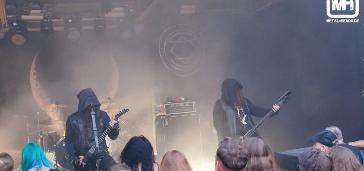 Uada auf der Bühne des ZappenDuster Open Air 2022. Die Gesichter der Musiker sind von großen Kapuzen verdeckt. Die Bühne ist ausschließlich von hinten fahl beleuchtet.