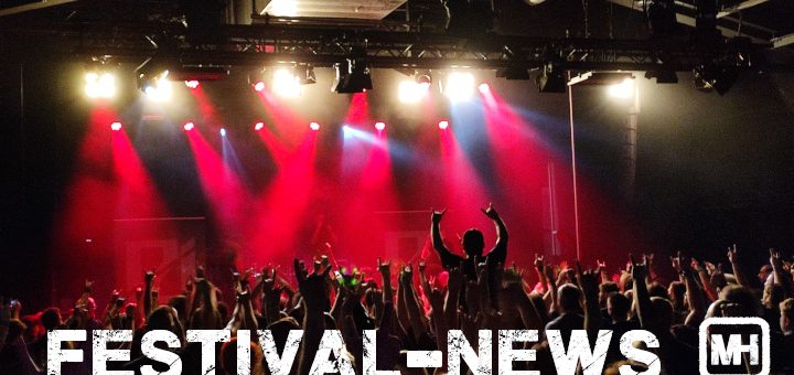 Publikum vor einer Bühne in rotem Licht.