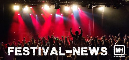 Publikum vor einer Bühne in rotem Licht.