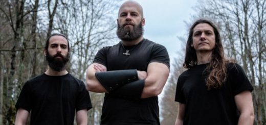 Die Bandmitglieder in schwarzen Shirts in einem Wald.