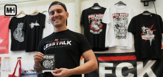 Infostand von "Kein Bock Auf Nazis". Ein Teammitglied präsentiert die Artikel.