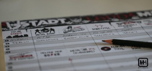 Der Spielblock von "Stadt - Land - Metal" liegt auf einem Tisch. Ein paar Felder sind ausgefüllt und ein Bleistift liegt auf dem Block.