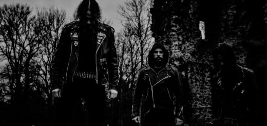 Die Band The Fals steht in schwarzer Kleidung mit Patronengürteln und Lederjacken in den Ruinen einer alten Burg.