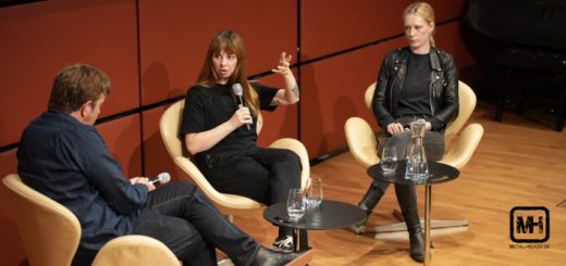 Podiumsdiskussion mit Sara Gacic in der Mitte und Linnea Olson rechts. Journalist Andreas Krieger hört aufmerksam zu, während Sara Gacic vehement spricht und gestikuliert.