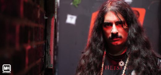 Daniel von Outlaw in der Nahaufnahme. Links ist unscharf eine Backsteinmauer zu sehen. Im Hintergrund befindet sich eine alte Metalltüre.