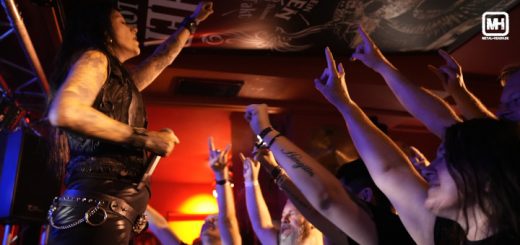 Britta Görtz steht vor dem Publikum, das ihr die gehörnten Hände entgegenstreckt.