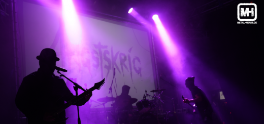 Angstskrig live 2023 Oberhausen: Blick auf die Bühne. Der Gitarrist links trägt einen Hut. Im Hintergrund das Band-Banner.