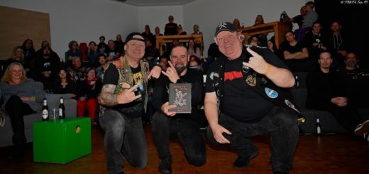 Kumpels in Kutten: Der Autor zwischen zwei Heavy-Metal-Fans mit Kutten und vor dem Publikum der Lesung in Gladbeck.