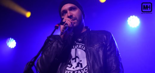 Michael Sackermann von MRW Concerts moderiert das "Eternal Flames of Ukrainian Resistance Festival" an. Er trägt ein Shirt mit einer nicht vollständig erkennbare, antifaschistischen Losung und hat eine Mütze auf.