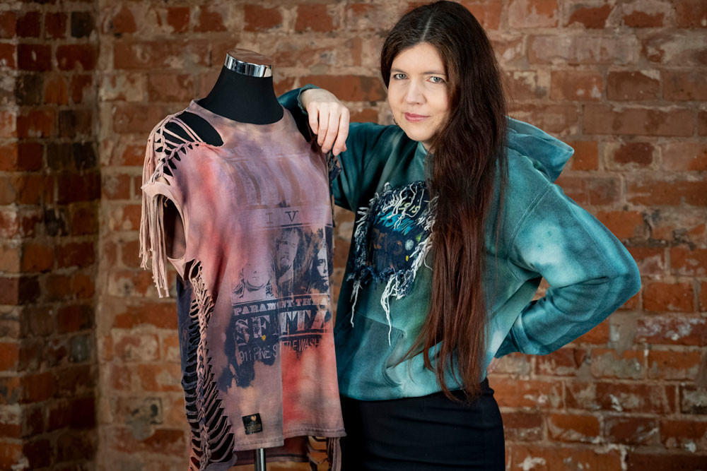 Alex Weber von Alextravagant lehnt an einem Torso, der ein Nirvana Shirt trägt, das aus dem Upcycling-Projekt stammt.