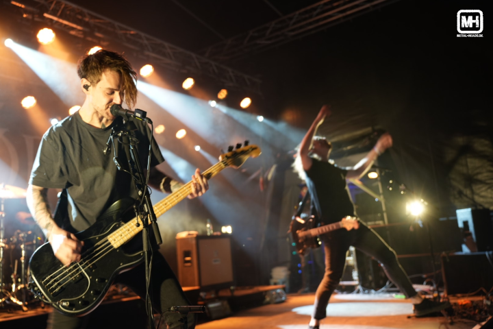 Fjørt auf der Bühne des Traumzeit Festivals in Duisburg 2024: Während der Bassist konzentriert spielt, lässt der Gitarrist sein Instrument los und gestikuliert wild mit dem Publikum.