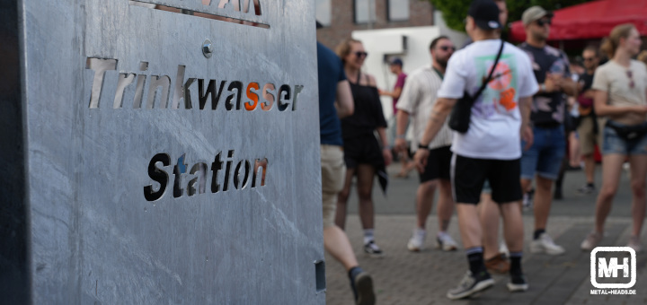 Foto einer Trinkwasser-Station auf dem Vainstream Festival 2023. Im Hintergrund etwas unschaft gestellt das Publikum.
