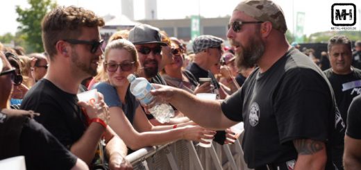 Ein großer Mann der Vainstream-Security verteilt Wasser aus einer Flasche an die Gäste in der ersten Reihe.