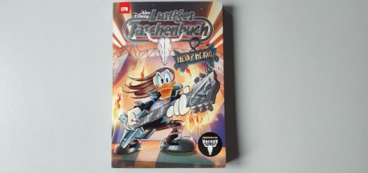 Das Lustige Taschenbuch "Heavy Metal" liegt auf einer grauen Tischplatte.