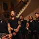 Amorphis stehen in einem historischen Treppenhaus.