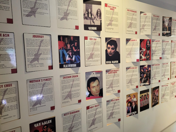 Eine Wand mit Info-Tafeln zu allen möglichen Bands und Music-Acts.