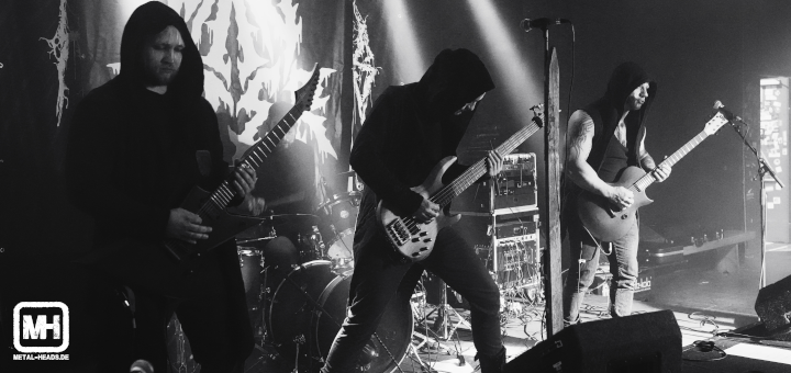 Blick auf die Bühne mit der Band Maneater, deren Musiker alle in Kapuzen verhüllt sind.