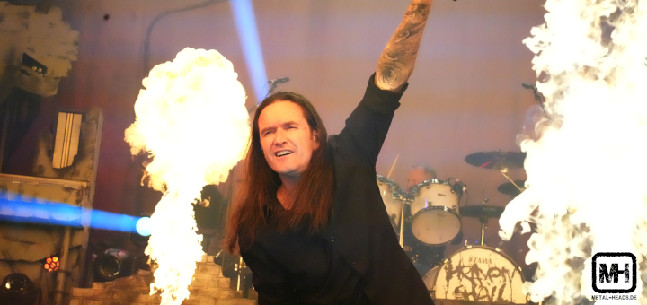 Der Sänger von Heaven Shall Burn streckt die Hand mit dem Mikro in die Höhe, während neben ihm Feuersäulen in die Höhe schießen.