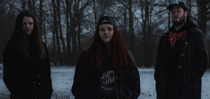 Die drei Mitglieder von Onyxsin im Schnee vor Bäumen.