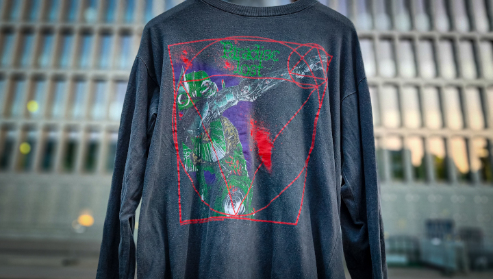 Ein Longsleeve vor einem Gebäude aufgehängt.