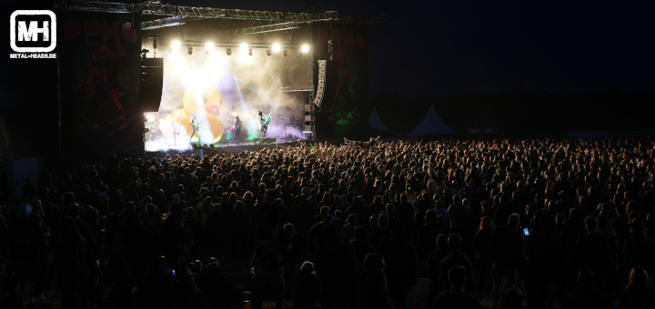Blick aus der Entfernung auf die Bühnenshow von Alestorm mit einer gewaltigen Menschenmenge vor der Bühne.